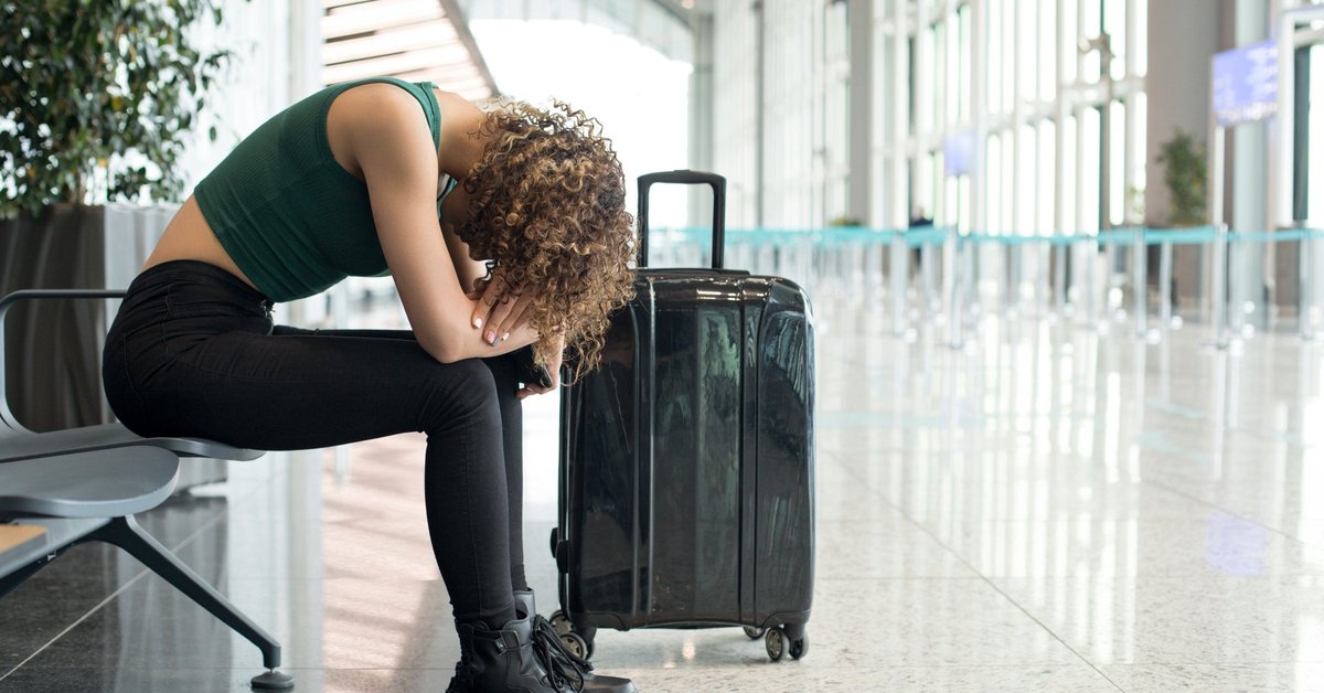 A woman sits dejectedly at the airport.