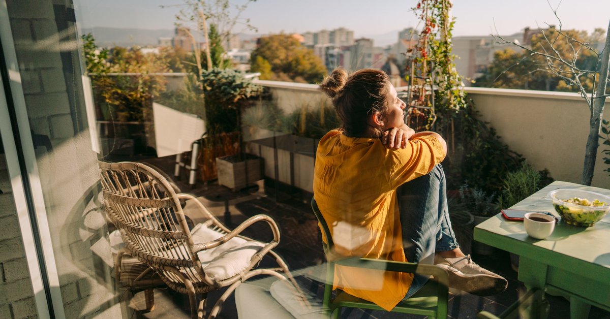 Woman sitting outside on her condo balcony.