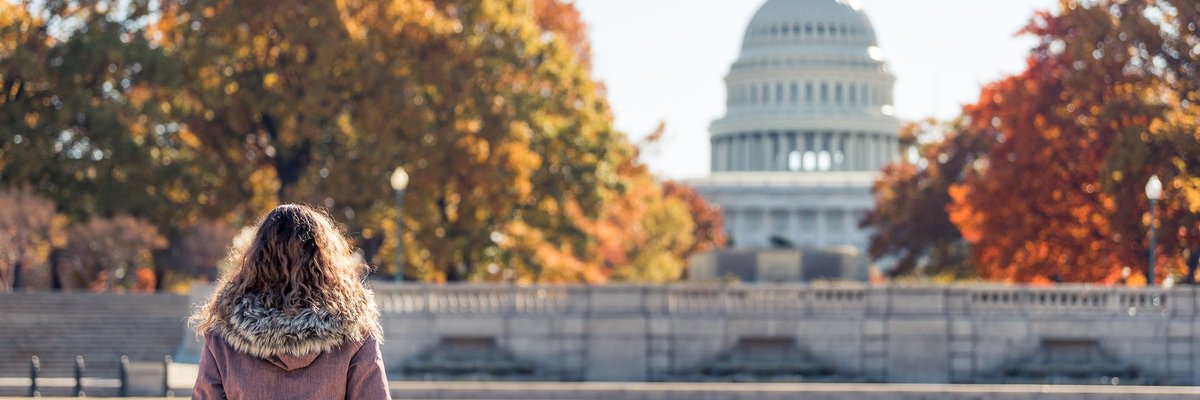 Woman sitting outside the capitol building on a fall day