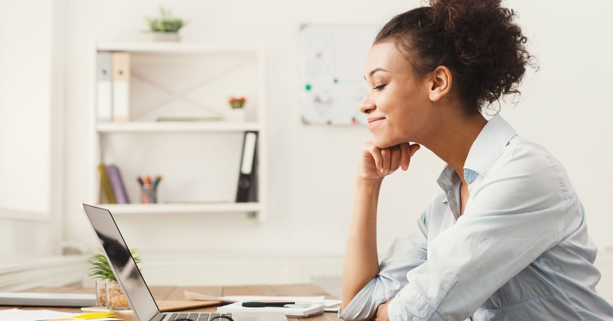 A woman smiling at her office desk.