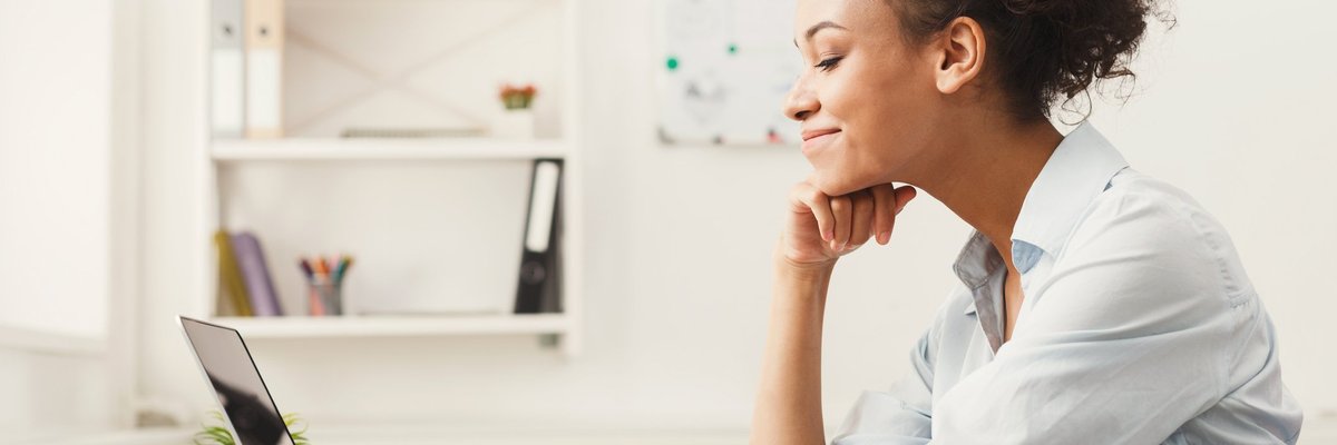 A woman smiling at her office desk.
