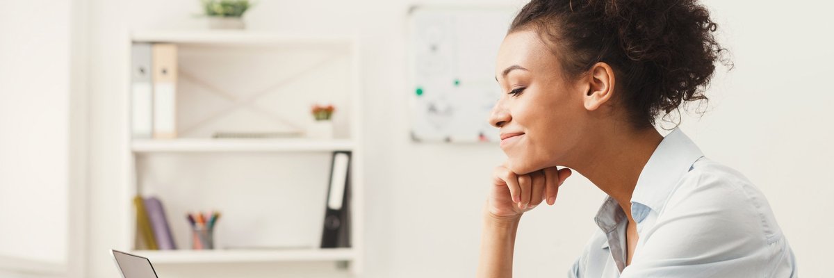 A woman smiling at her office desk.