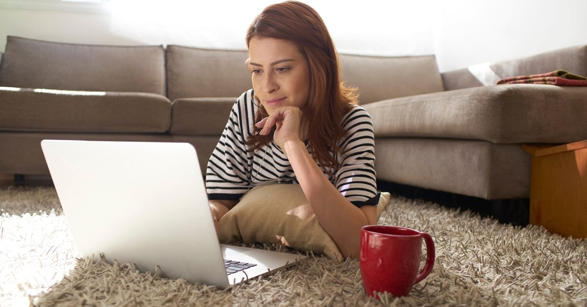 Woman using her laptop on her living room floor