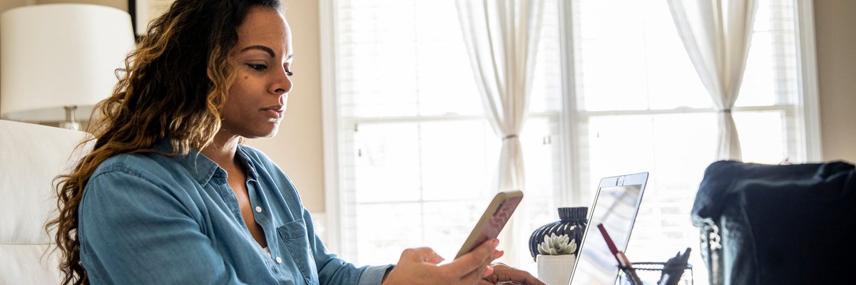 Woman using laptop and smartphone at home