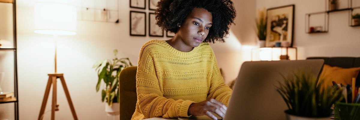 Woman using laptop at home for work or study.