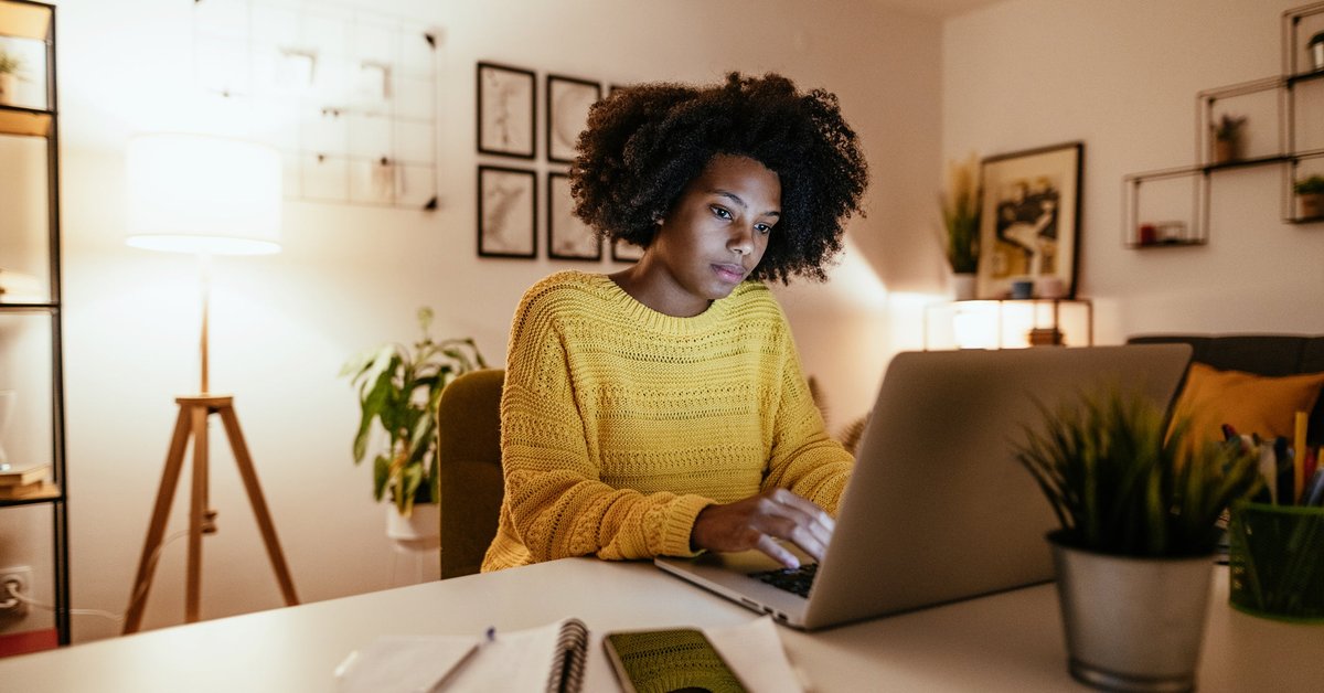 Woman using laptop at home for work or study.