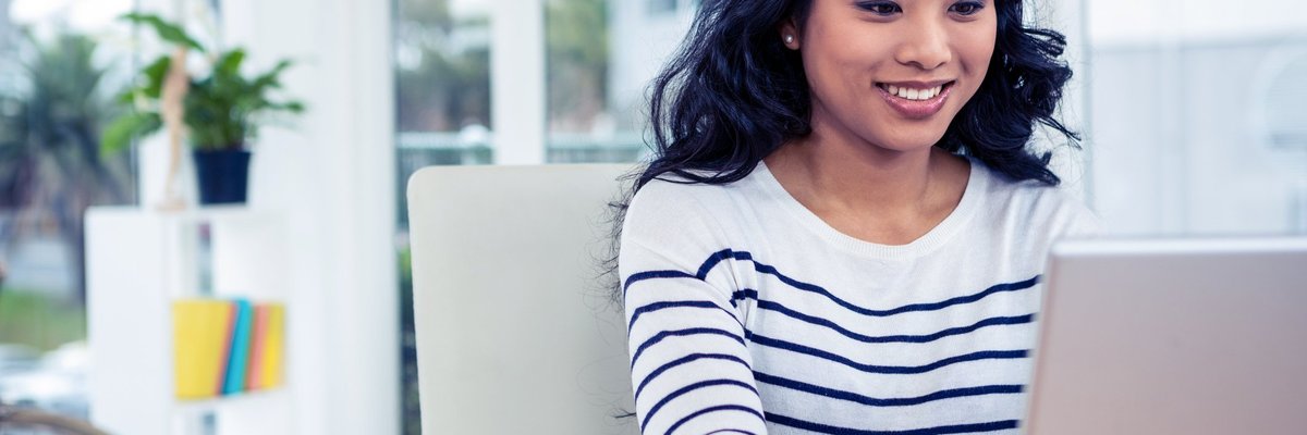 Woman using laptop and smiling.