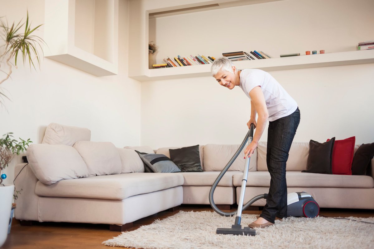 Woman vacuuming her rug.