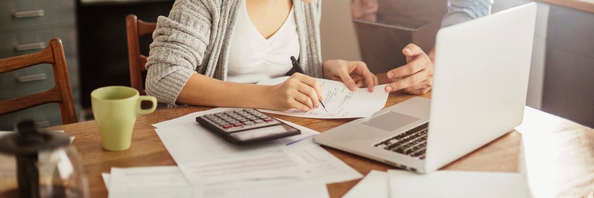 Woman with glasses making calculations.