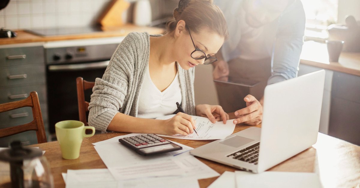 Woman with glasses making calculations.