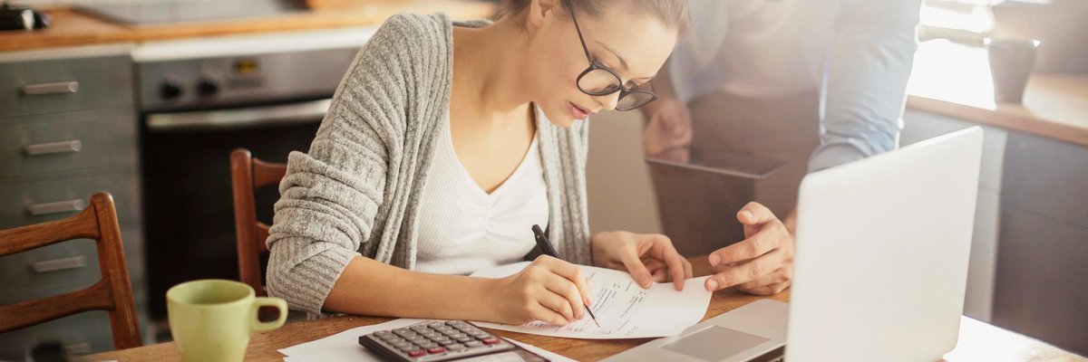 Woman with glasses making calculations.