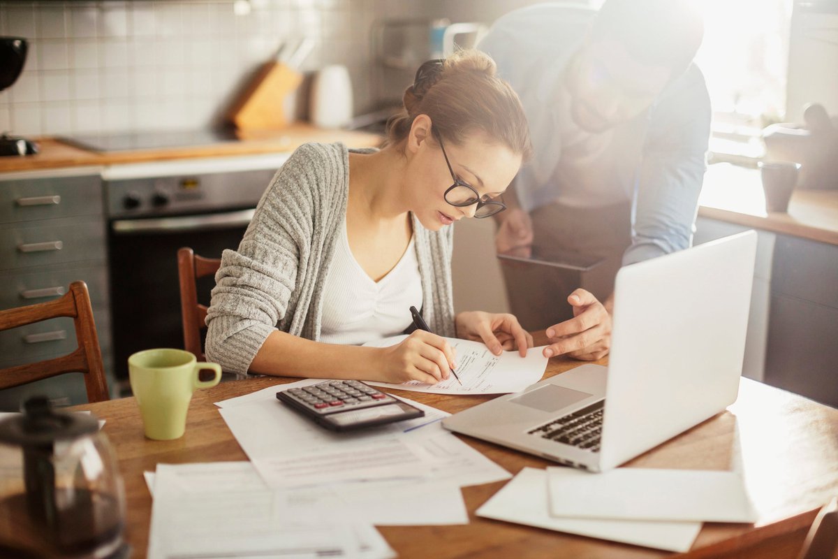 Woman with glasses making calculations.