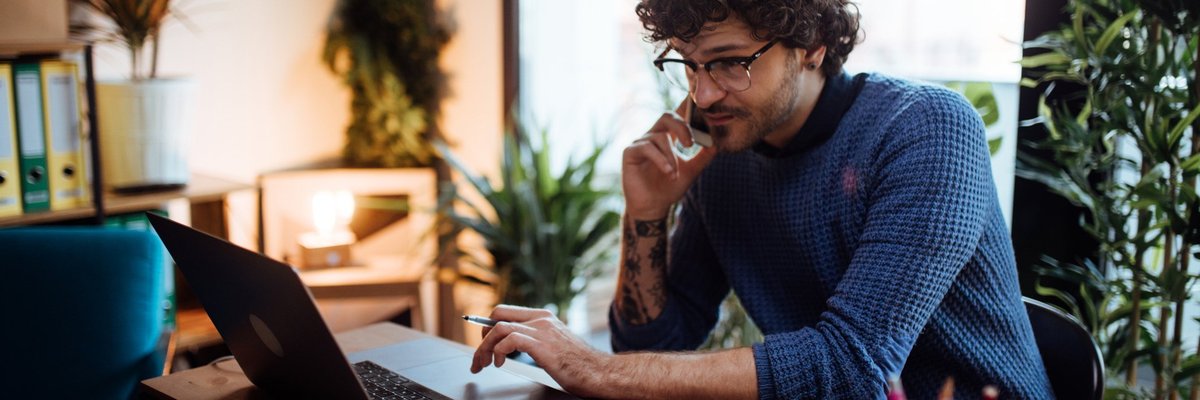 Young Man On Phone Looking At Monitor