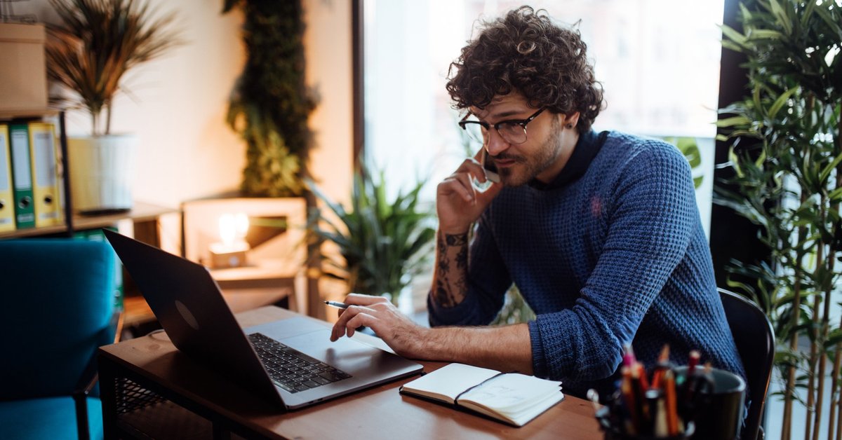 Young Man On Phone Looking At Monitor