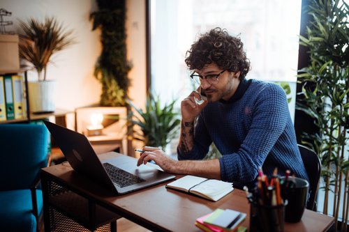 Young Man On Phone Looking At Monitor