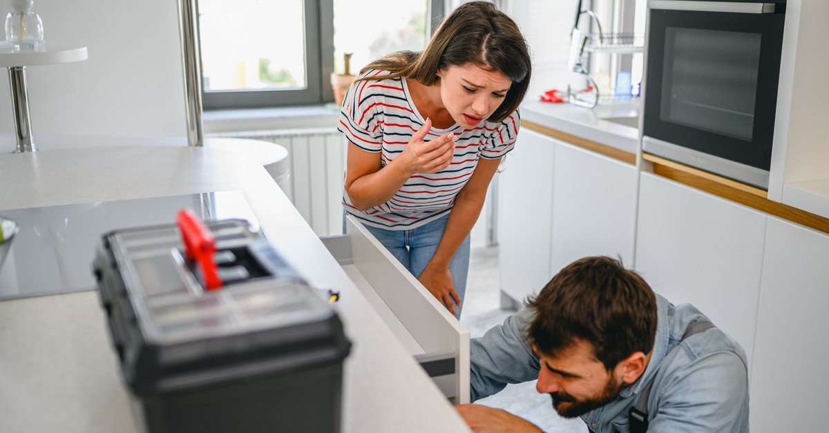 Young couple inspecting drawers with toolbox sitting nearby