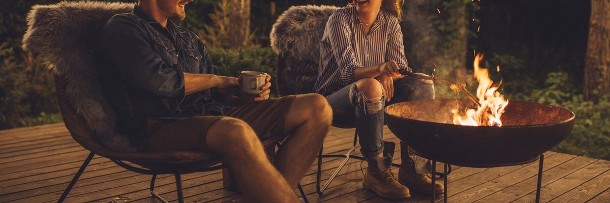 Young couple relaxing by a campfire.