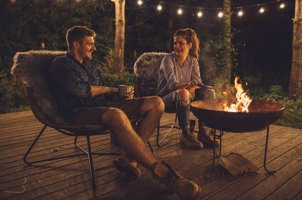 Young couple relaxing by a campfire.