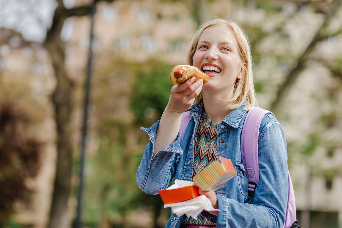 young woman eating hot dog