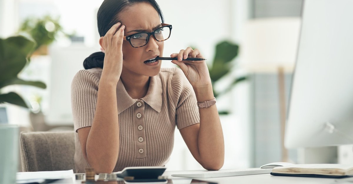 A young woman looks concerned as she reads the latest cryptocurrency news on her computer.