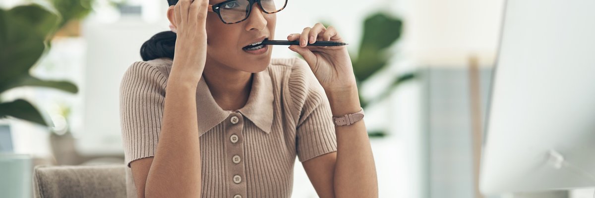 A young woman looks concerned as she reads the latest cryptocurrency news on her computer.