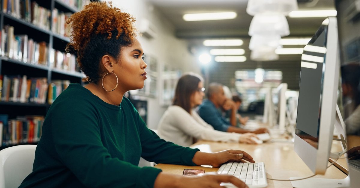 Young woman using laptop at the library