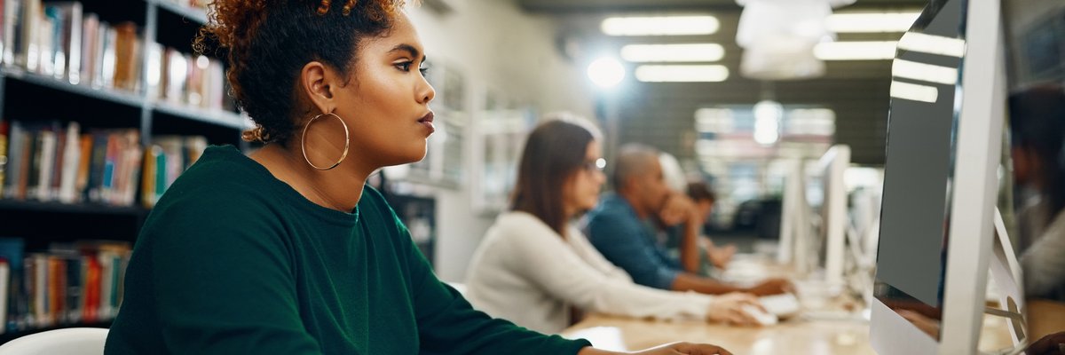 Young woman using laptop at the library