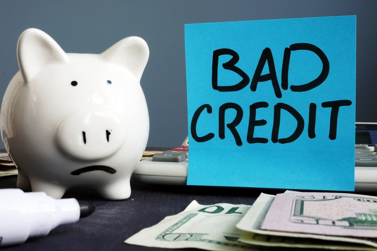 Piggy bank next to a sign that says "bad credit"