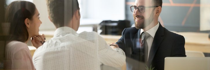 A couple talking to a bank officer at a desk.