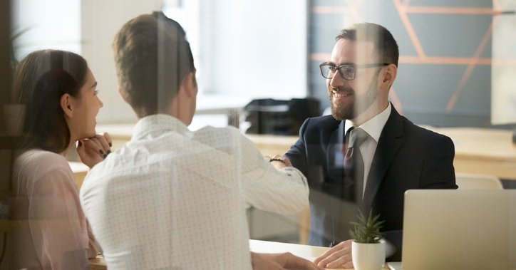 A couple talking to a bank officer at a desk.