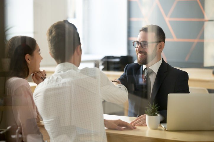 A couple talking to a bank officer at a desk.