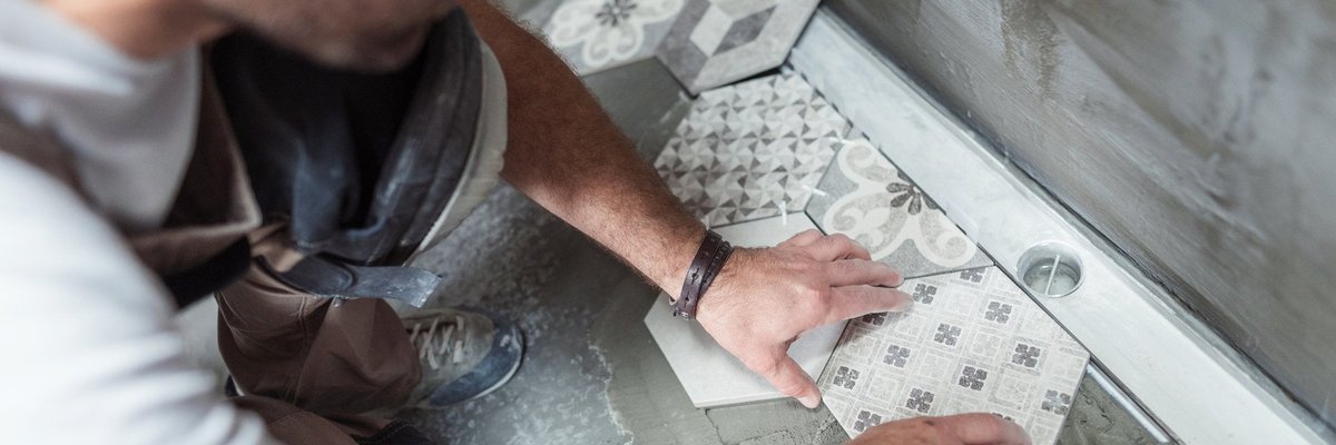 Man laying new tile in bathroom.