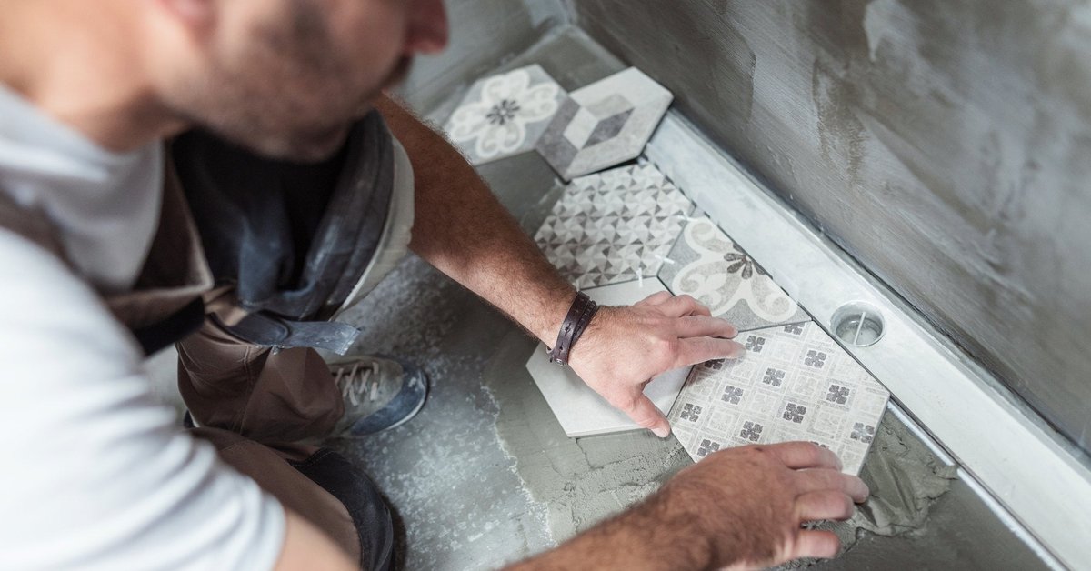 Man laying new tile in bathroom.