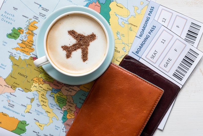 boarding passes and a latte with an airplane drawn on the foam