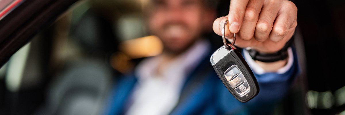 Man holding keys to new car.