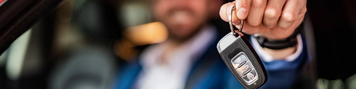 Man holding keys to new car.