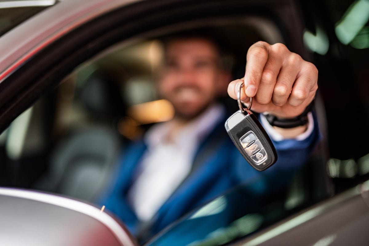 Man holding keys to new car.