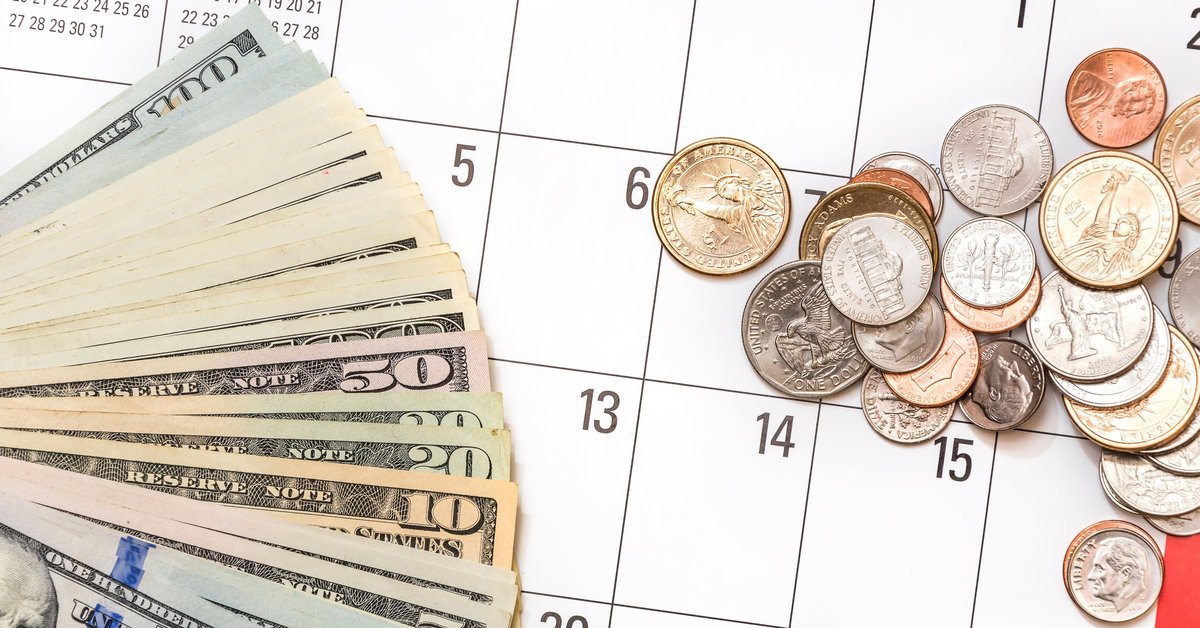 Bills and coins sitting on calendar