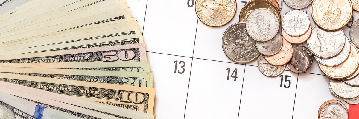 Bills and coins sitting on calendar