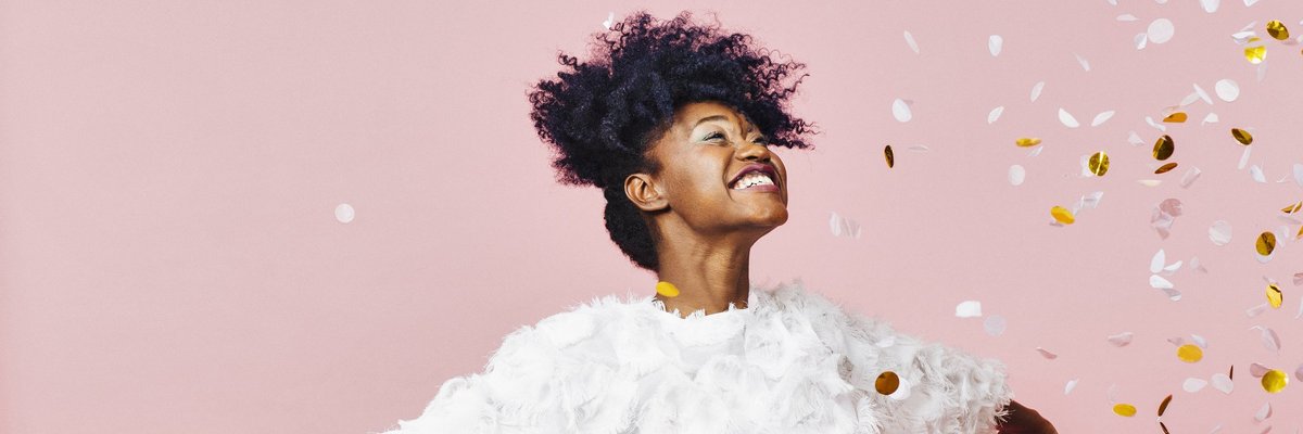 Happy girl throwing confetti in the air