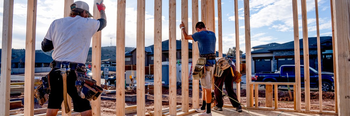 A group of construction workers building the frame of a new house.