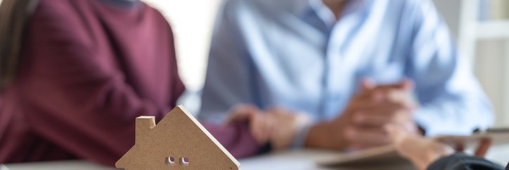 A small wooden house with couple blurred in background.