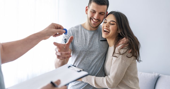 A couple receiving keys to a house.