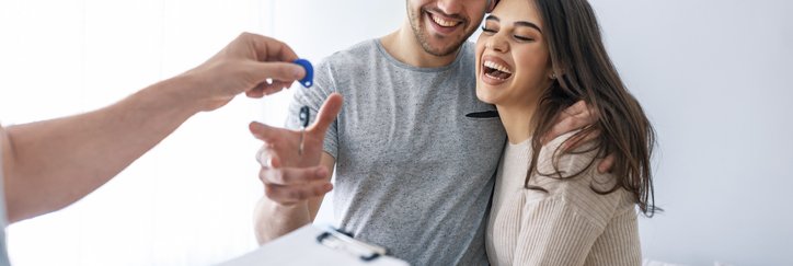 A couple receiving keys to a house.