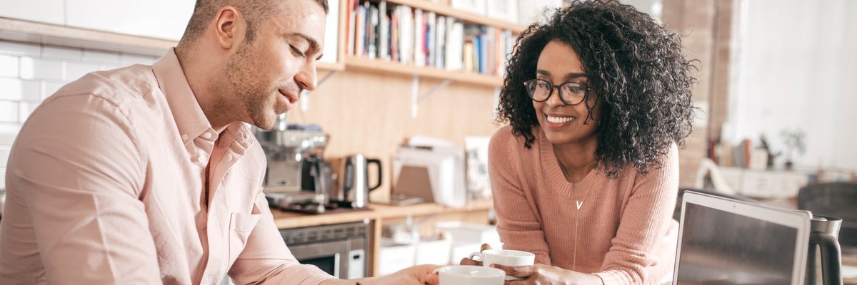 A couple go over their personal finances in their kitchen.