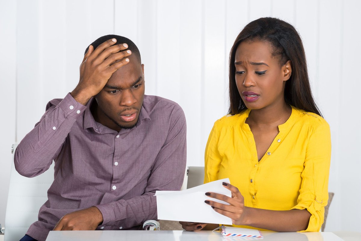 A couple looking at a financial statement in dismay