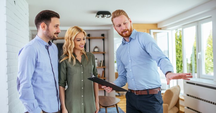 A couple looks at a house with a real estate agent.