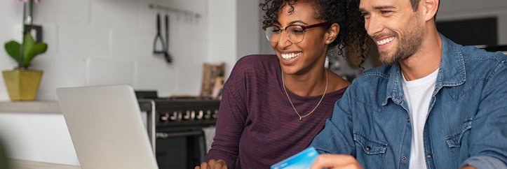 A man and woman shopping online with a credit card