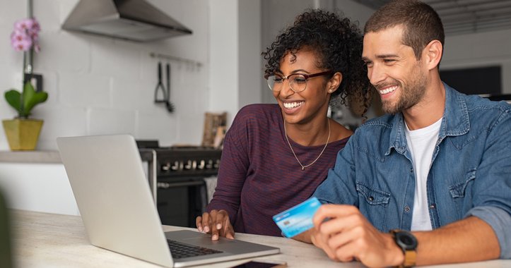 A man and woman shopping online with a credit card