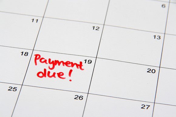 A close up on a calendar with "payment due!" written on the 19th.